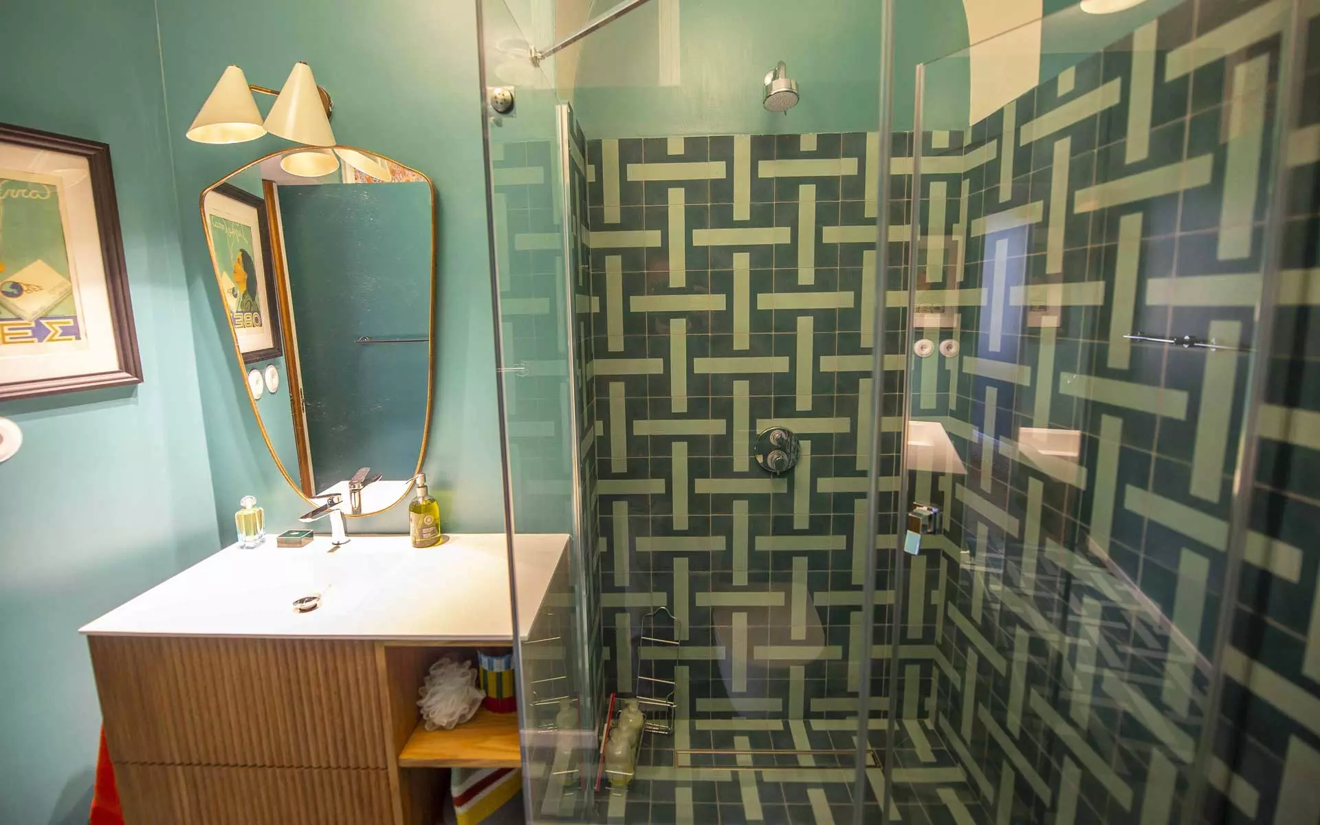 Baño con baldosas de ducha en verde oscuro y paredes en verde menta