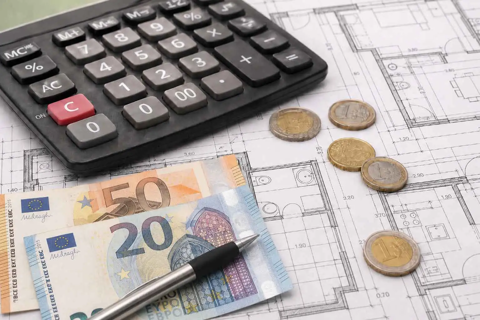 Precio de reforma de piso de 60 m² en Madrid Calculadora, planos de vivienda, monedas y billetes de euro sobre una mesa de trabajo para representar el precio de reforma en Madrid de un piso de 60 metros cuadrados.