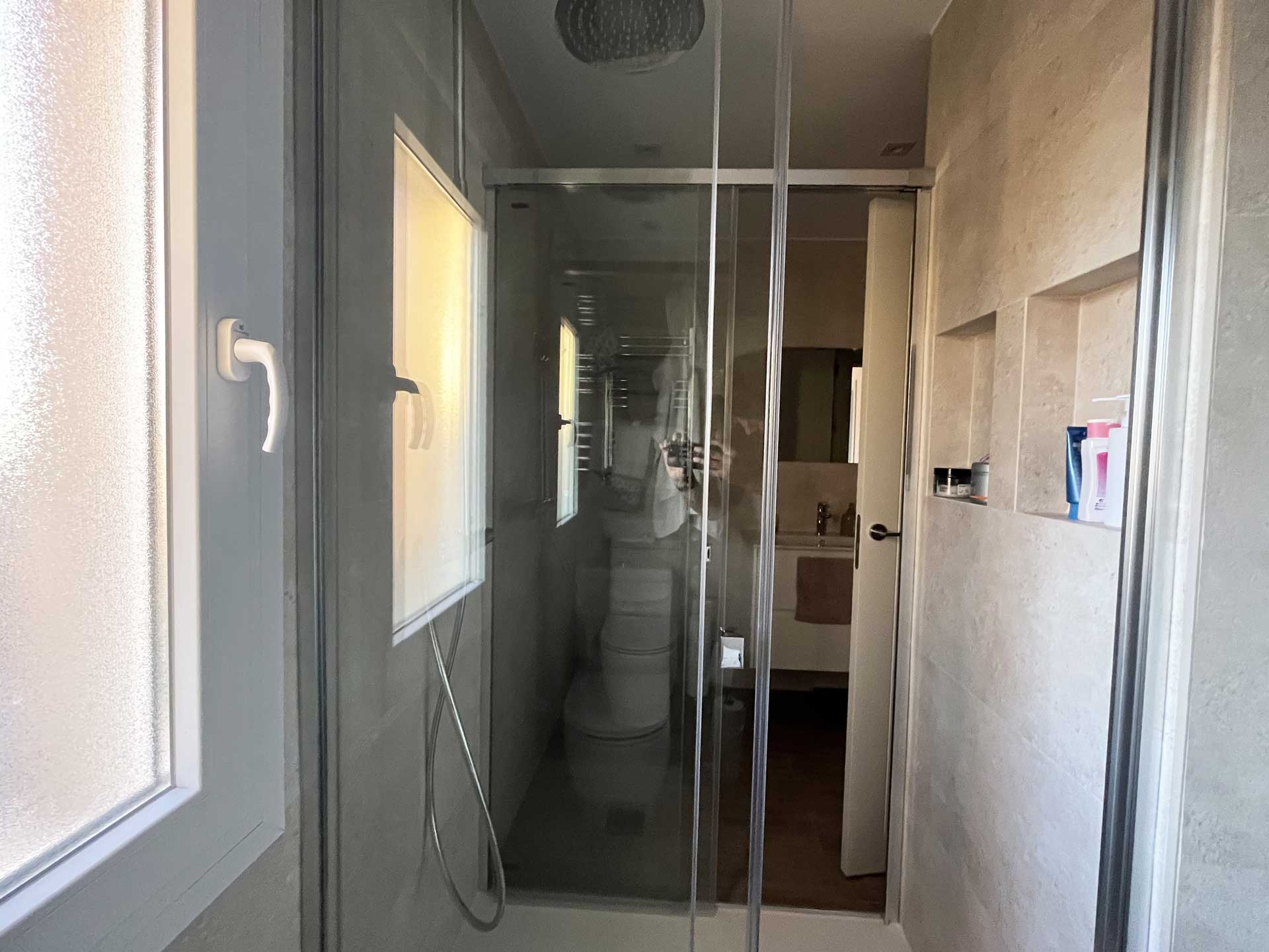 Ducha compartida entre la zona de dormitorios y el dormitorio principal realizada por la empresa de reformas Honrados en chalé de Pozuelo de Alarcón