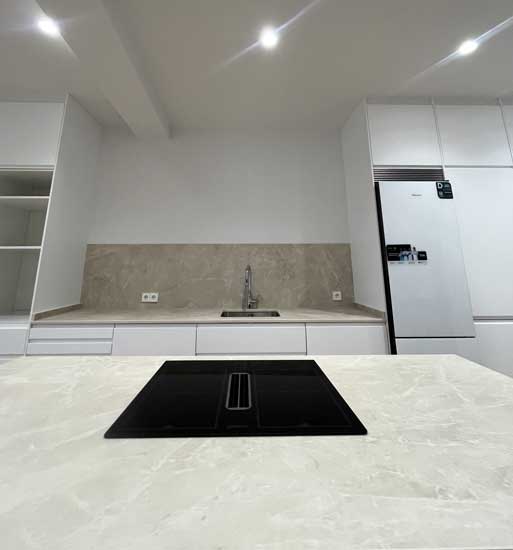 Imagen frontal de una cocina con isla y frontal de muebles modulares de Ikea en reforma en Tirso de Molina.