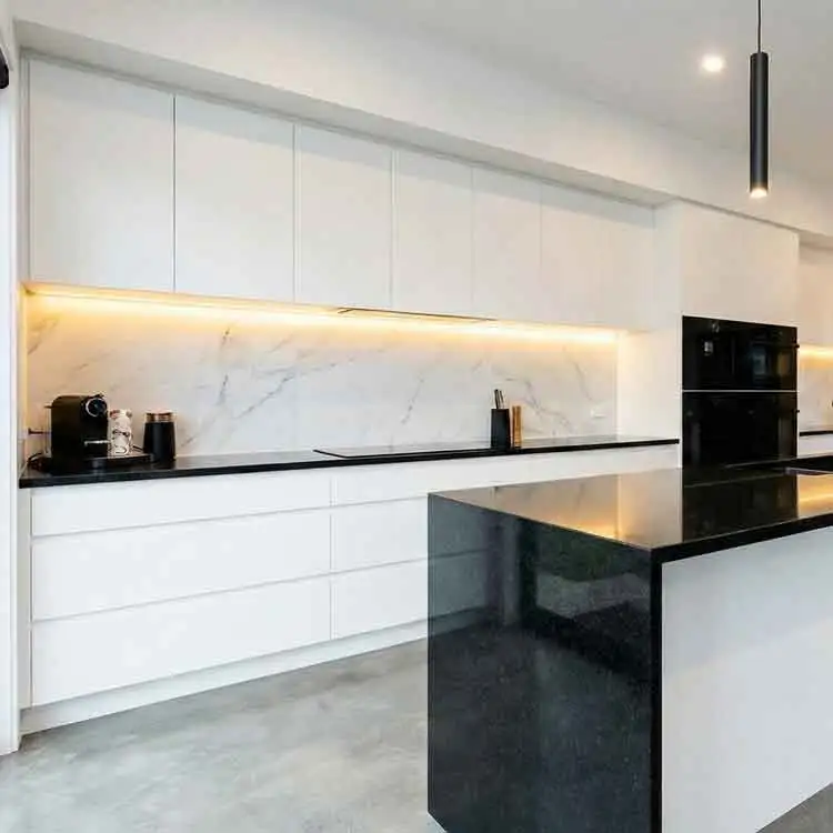 Cocina blanca con encimera en negro y luces LED Moderna cocina en Madrid, en color blanco con encimera en negro y luces LED bajo los muebles, con una isla central y electrodomésticos oscuros.