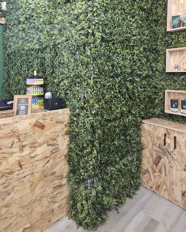 Reforma de local en Malasaña. Imagen interior de la tienda de cultura cannábica decorada con césped artificial y maderas OSB