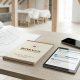 Descarga el manual técnico de obra gratis de Honrados, presentado sobre una mesa de trabajo con planos arquitectónicos, tablet con checklist digital, móvil y bolígrafo, en un espacio luminoso de reforma e interiorismo.
