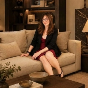 camila-espinosa-fin-minimalismo Camila Espinosa sentada en un salón de estilo contemporáneo con tonos tierra, un espacio que representa el fin del minimalismo y el regreso de ambientes cálidos y acogedores.
