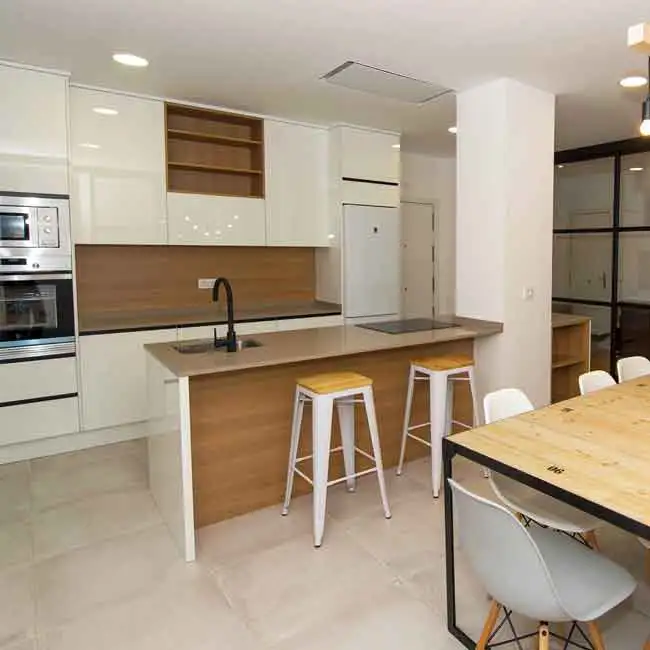 Cocina con zona de trabajo optimizado | 5 errores evitar al diseñar cocina Cocina en Madrid con zona de trabajo optimizada, isla central, barra con taburetes y comedor integrado, como ejemplo de uso correcto dentro de los cinco errores a evitar al diseñar tu cocina.