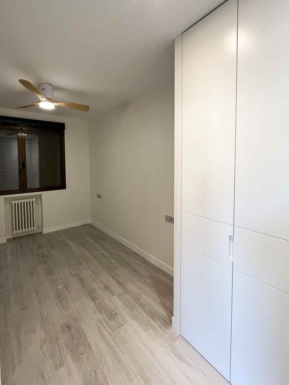 oficina-ciudad-barcelona-madrid-convertida-dos-viviendas-dormitorio-juvenil-piso-uno Dormitorio juvenil luminoso con armario empotrado y ventilador de techo en el Piso Uno de la oficina convertida en dos viviendas en Pacífico.
