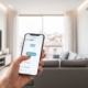 Mano controlando persianas inteligentes desde aplicación móvil de vivienda en Madrid con domótica invisible integrada durante la reforma integral.